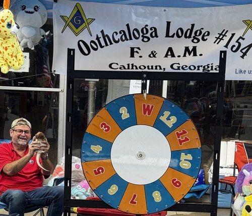 Lodge member with a prize wheel at the Oothcaloga Lodge community booth