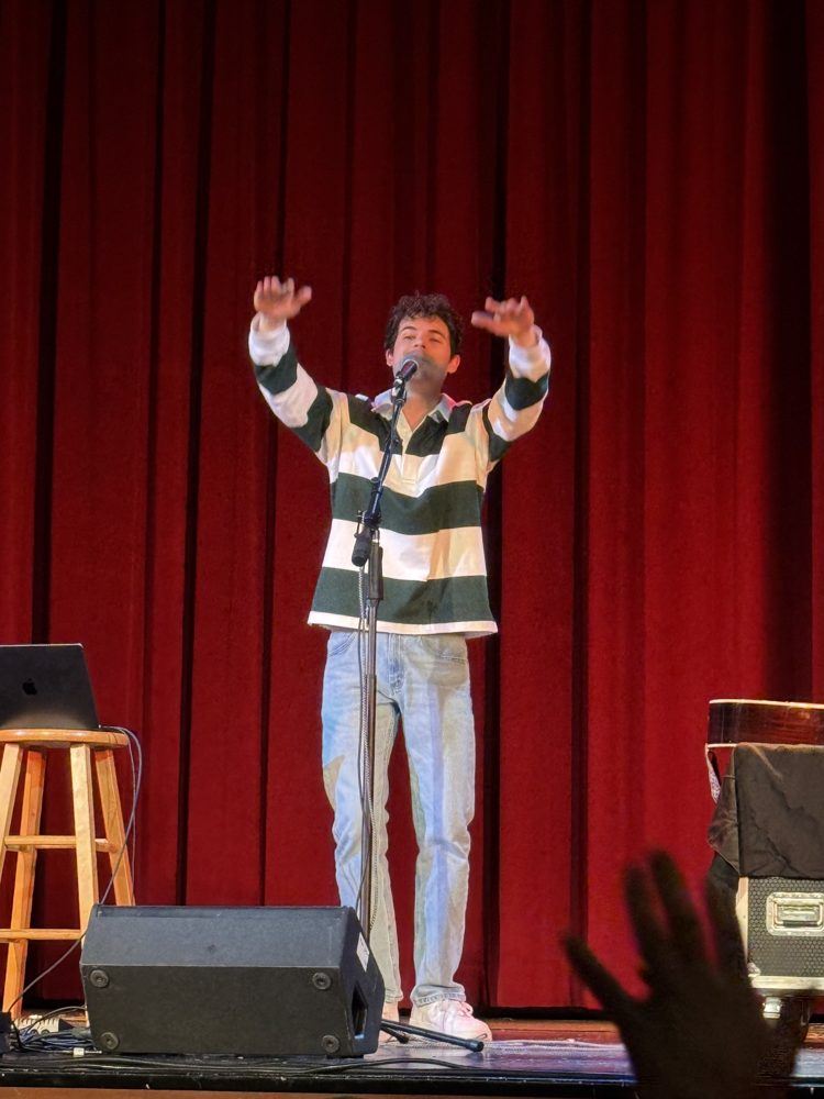 Michael O'Brien performing on stage with arms raised