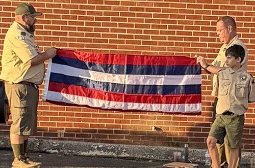 Scouts and a Scout leader folding a retired flag