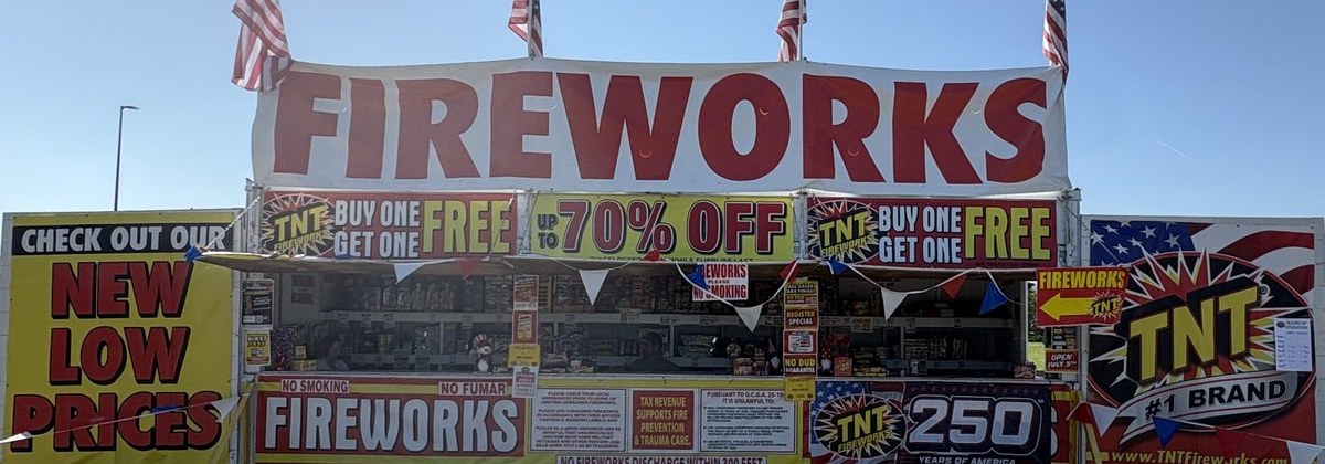 TNT Fireworks stand banner with American flags