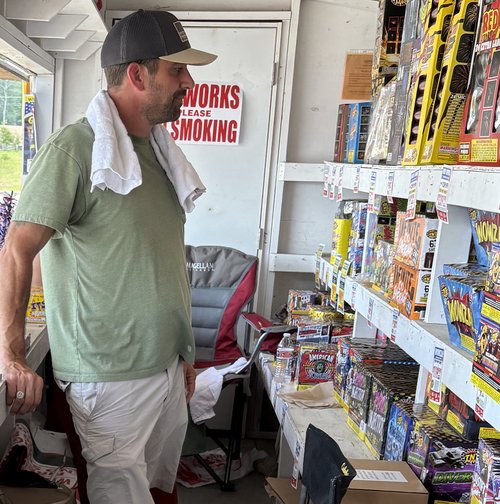 Fireworks stand volunteer restocking shelves